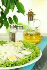 Delicious salad with eggs, cabbage and cucumbers on table