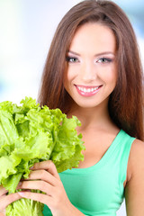 Beautiful girl with fresh salad on light background