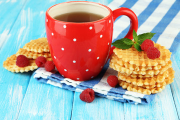 Cup of tea with cookies and raspberries on table close-up