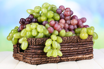 Ripe green and purple grapes in basket