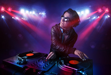 Teenager dj mixing records in front of a crowd on stage