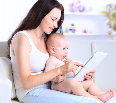 mother and baby are looking to play and read tablet - Powered by Adobe