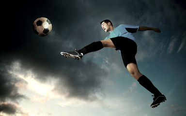 Fototapeta na wymiar football player on soccer field of stadium with drammatic sky