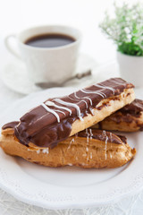 Chocolate eclairs on white plate