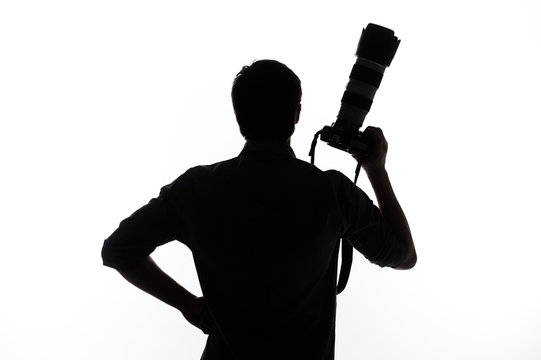 Man with camera. Silhouette of man holding camera and holding ha