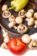 Mushrooms and fresh vegetables on the rusty pan