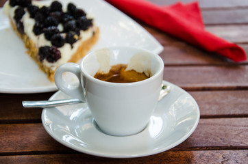 Obraz na płótnie Canvas White espresso cup and a piece of blackberry cheesecake