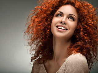 Red Hair. Beautiful Woman with Curly Long Hair. High quality ima