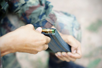 Fototapeta premium inserting ammunition into the cartridge