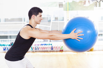 Handsome man exercising with Pilates ball
