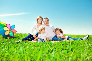 Happy family in outdoor park  at sunny day. Mom, dad and two dau