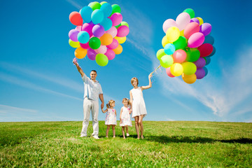 Happy family holding colorful balloons. Mom, dad and two daughte