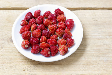 Wild strawberries on wooden table. Selective focus