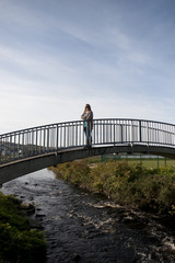 woman silhouetted walking on a modern bridge