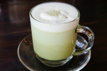 Hot green tea on wood table in the cafe