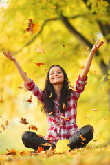 woman drop leaves in autumn park