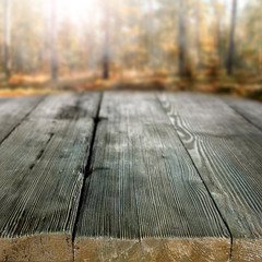 Rustic table with copy space for product placement and background of autumn forest.