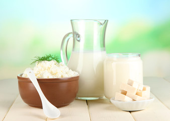 Fresh dairy products on wooden table on natural background