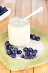 Fresh yogurt with blueberry on wooden table close-up