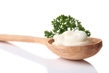 Sour cream in spoon isolated on white