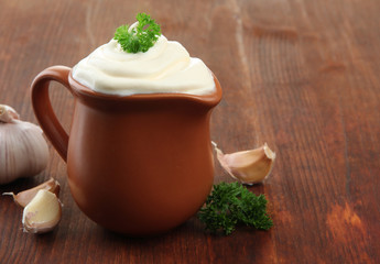 Sour cream in pitcher on table close-up
