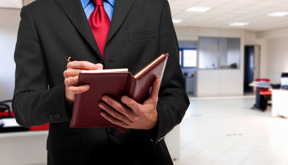 Businessman writing on his agenda