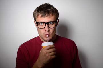 Man drinking from a disposable paper cup with a straw
