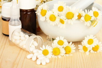 Obraz na płótnie Canvas Medicine chamomile flowers on wooden table