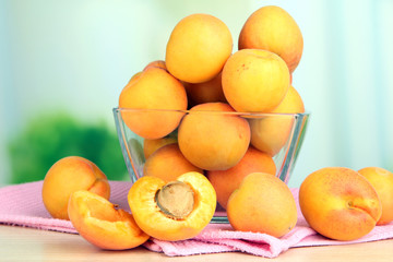 Naklejka na ściany i meble Fresh natural apricot in bowl on table in kitchen