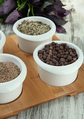 Assortment of spices in  white  bowls, on wooden background