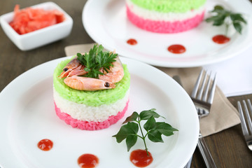 Obraz na płótnie Canvas Colored rice on plates on napkins on wooden table