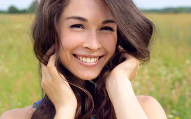 Happy young beautiful woman in field