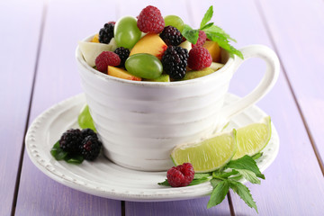 Fruit salad in cup on wooden table