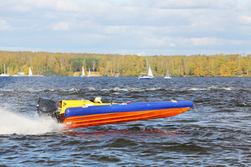 Sportsman fast  at power boat on river at competitions in fall.