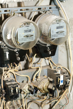 Two old, dirty meters for electricity with lot of wires