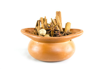Brown pot with cinnamon star anise on white background.