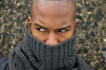 Black male fashion model with gray scarf covering face