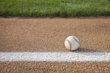 Baseball on base path with grass infield