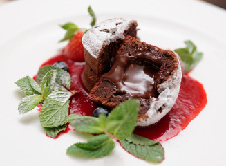 Chocolate fondant with berry sauce cut in halves