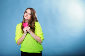 Happy girl with mobile phone in pink cover
