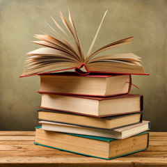 Vintage old books on wooden table over grunge background