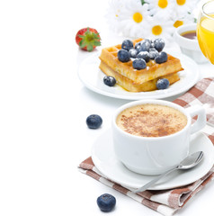 cup of cappuccino, belgian waffles with blueberries
