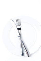 fork and knife on a white plate, isolated