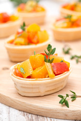 tartlets with roasted vegetables and thyme on board, close-up