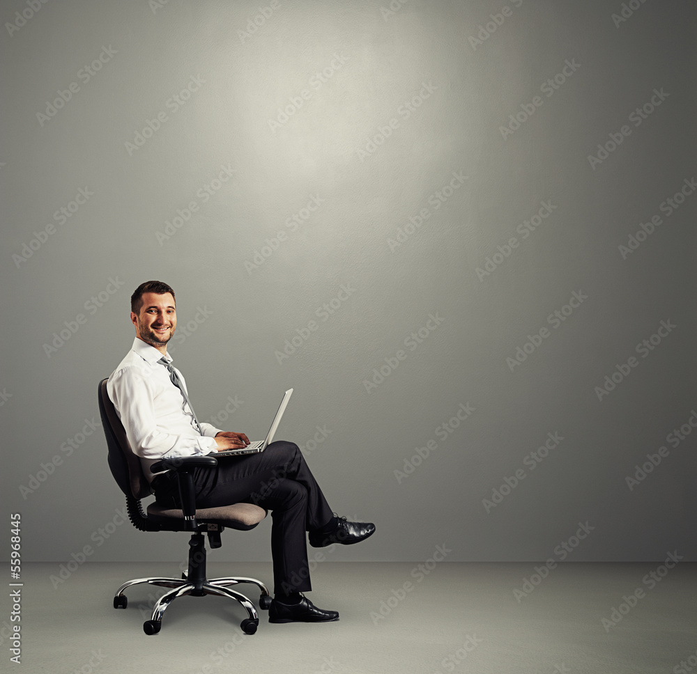 Wall mural man with laptop sitting in grey room