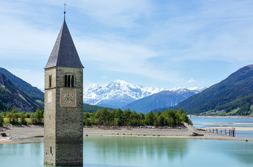 The bell tower in Reschensee and family (Italy).