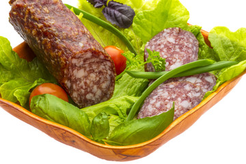 Ripe salami with salad, basil, onion and tomato