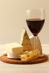 Composition with wine,various types of  cheese  on wooden table