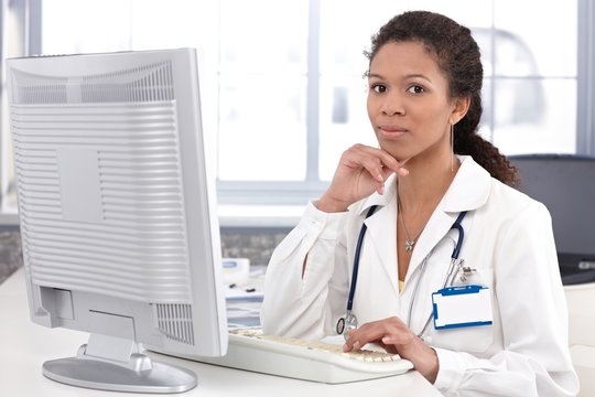 Portrait of young female doctor with computer