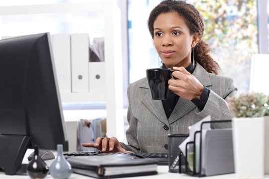 Afro businesswoman at work drinking tea